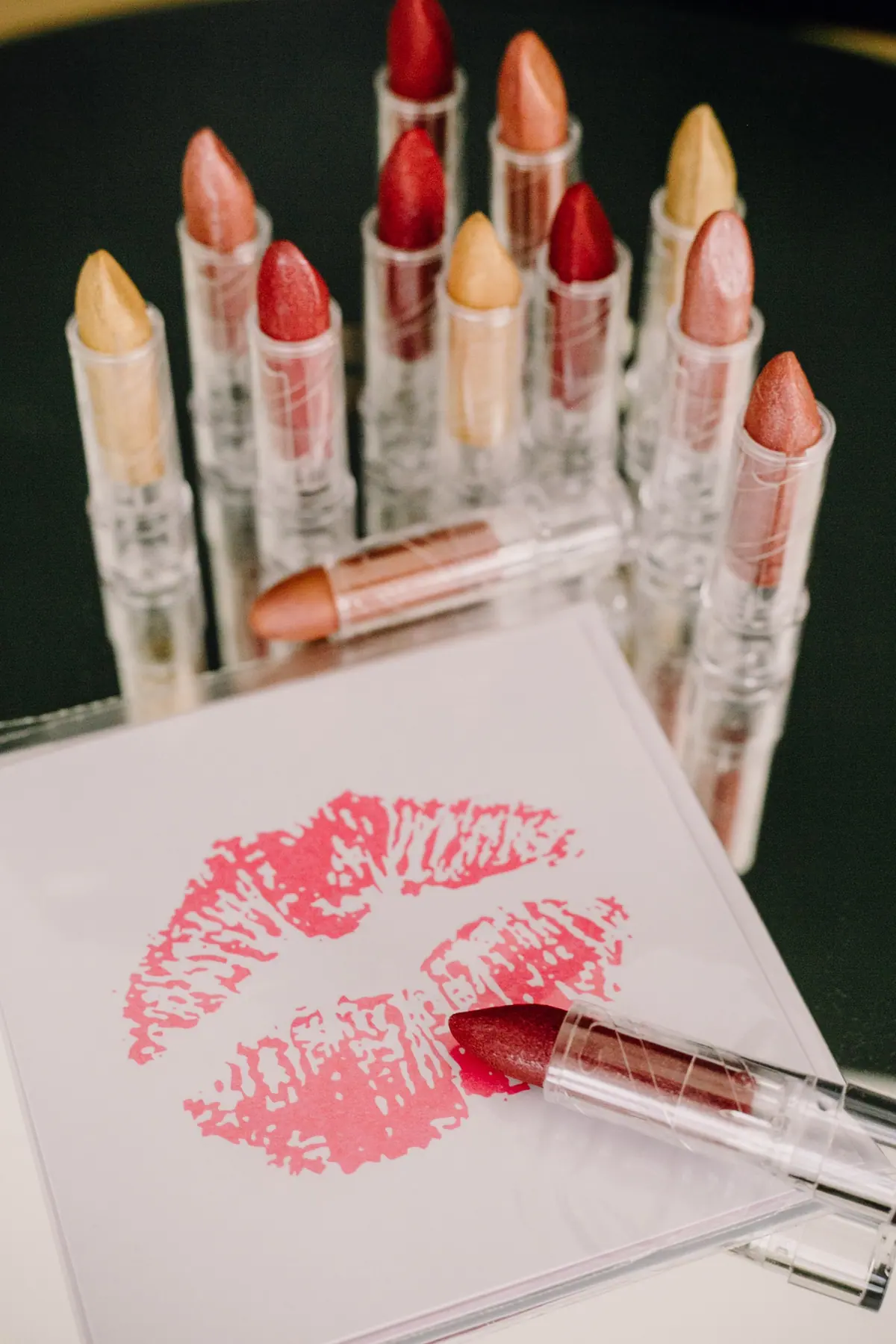 Schokolade-Lippenstifte vor einer Karte mit rotem Kussmund